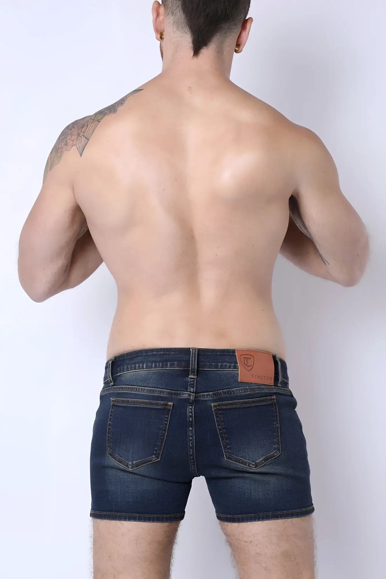 Dark blue denim soma 2.0 booty shorts showing back side with brown leather patch on waistband