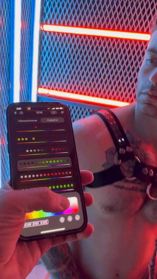 Black smartphone displaying color adjustment app with vibrant red and blue neon lights background for soundwave bulldog harness