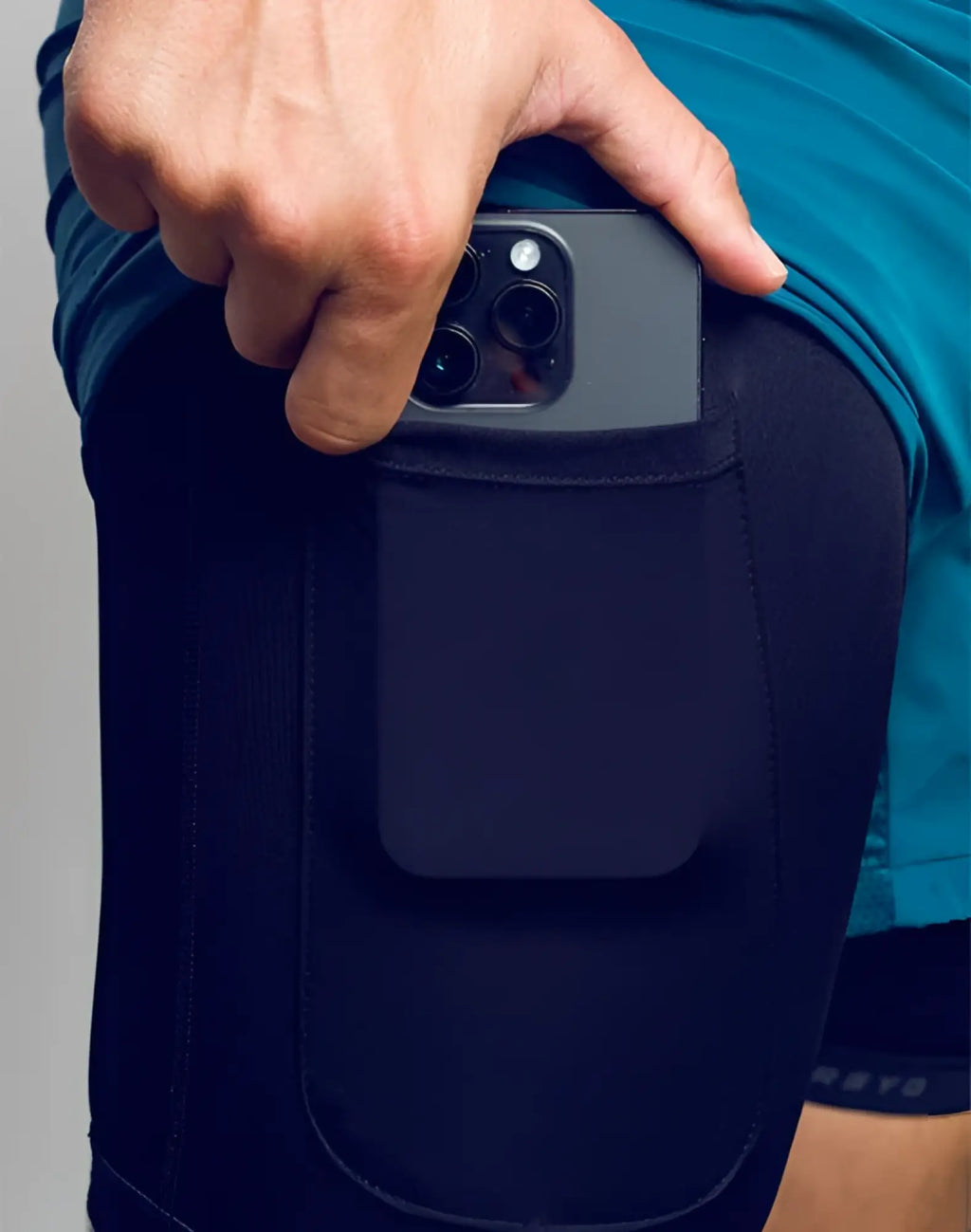 Black SPR FLEX SHORT athletic leggings with built-in pocket holding a dark gray smartphone for secure storage