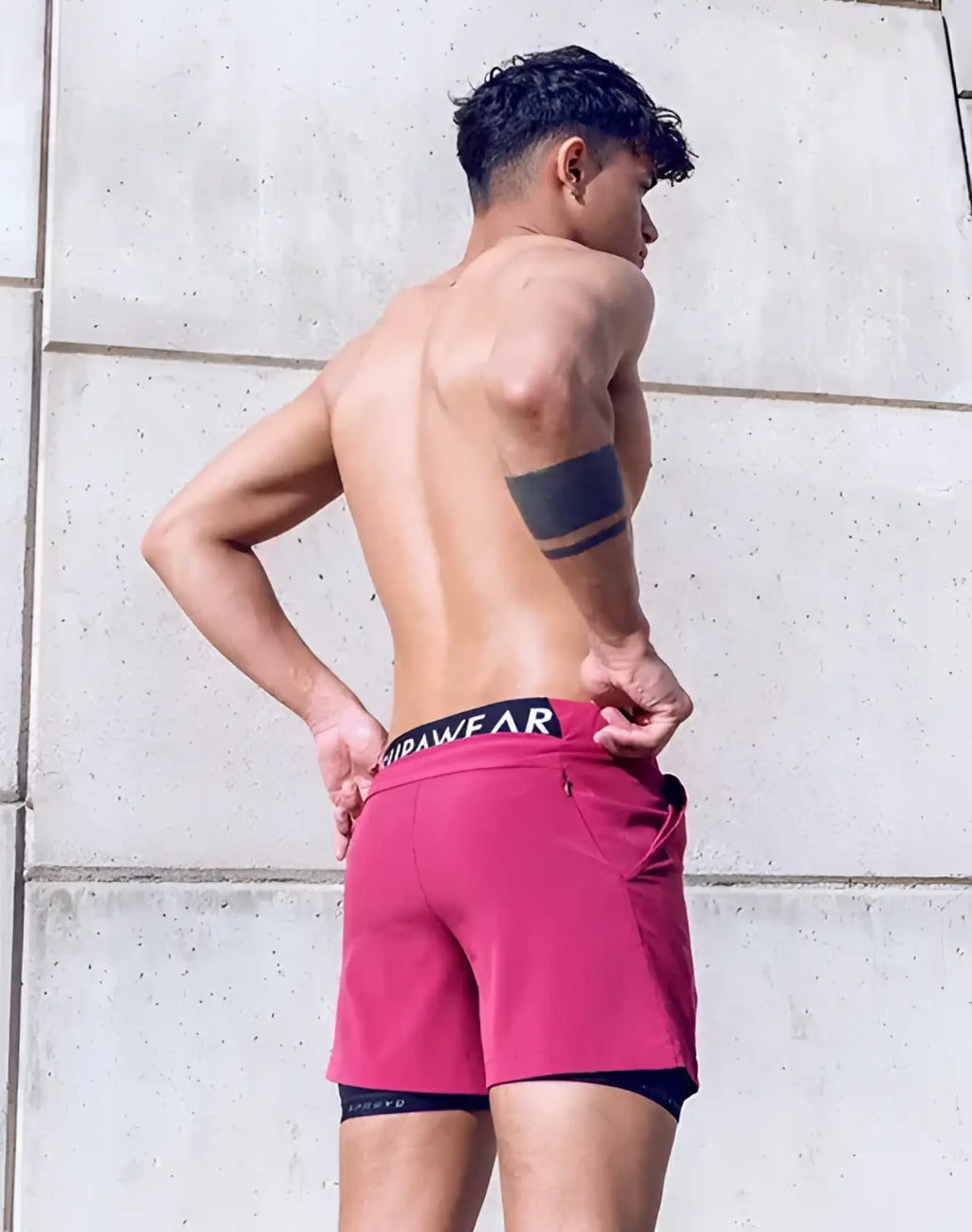 Spr max short vibrant fuchsia athletic shorts with black waistband and white lettering layered over dark blue compression shorts