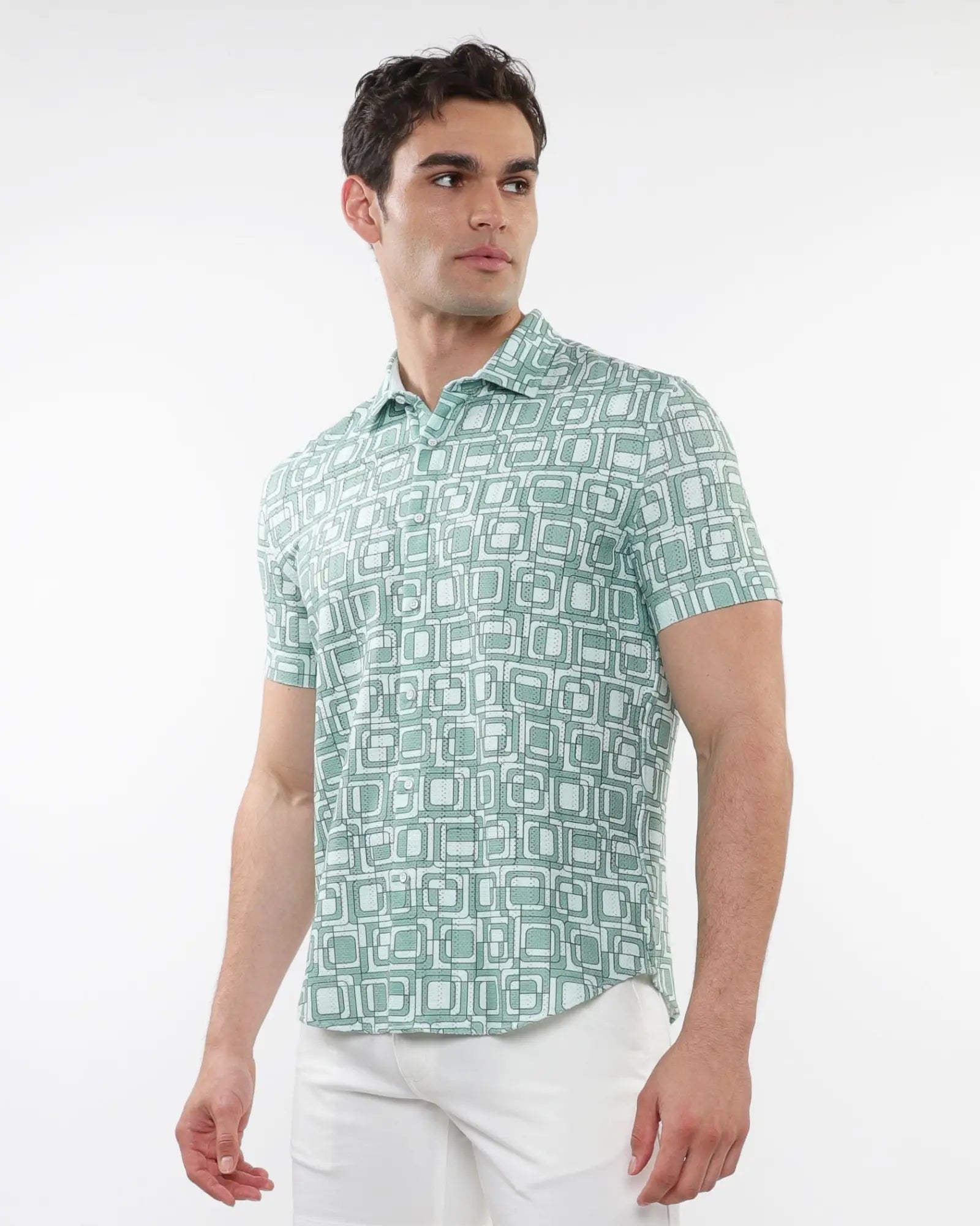 A man wearing a light green and white squares print open knit short-sleeved polo shirt