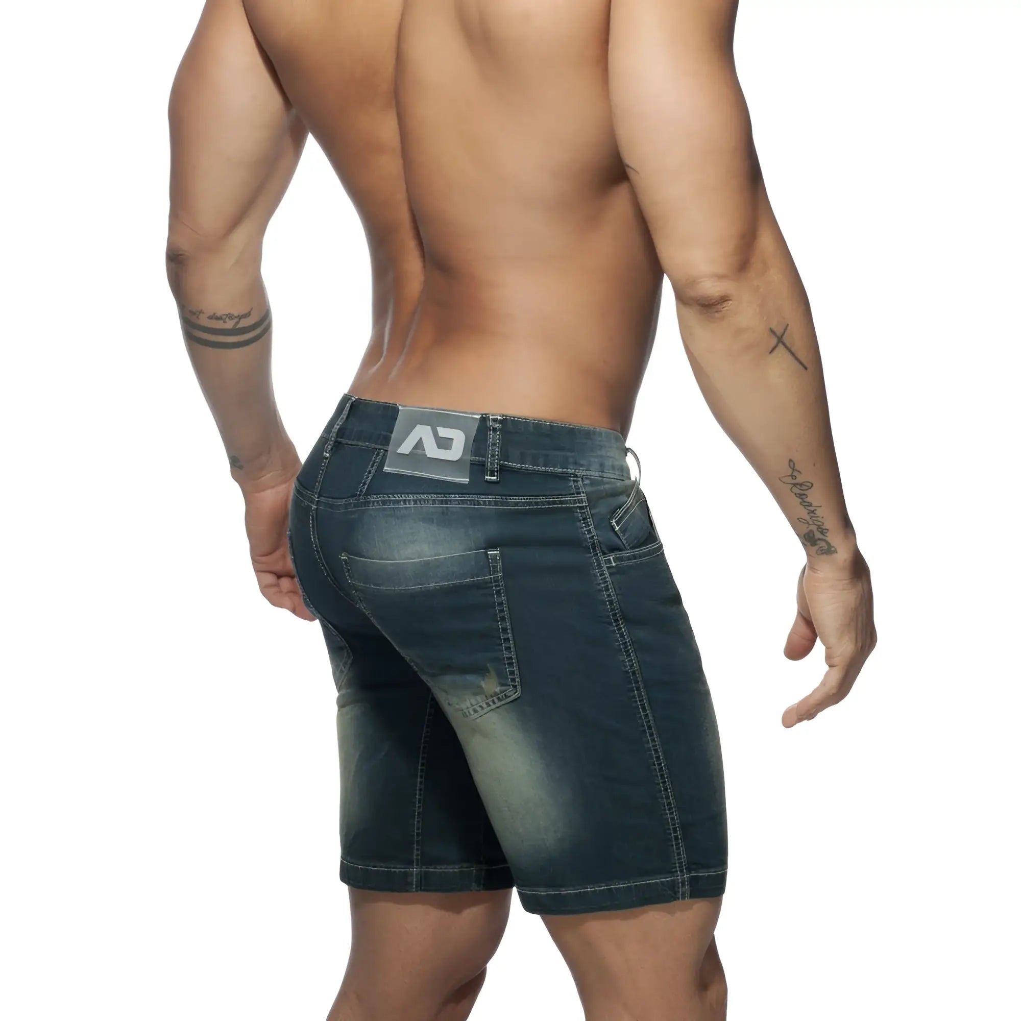 Back view of squat bermuda jeans dark blue denim shorts with faded wash distressed details and gray branded patch