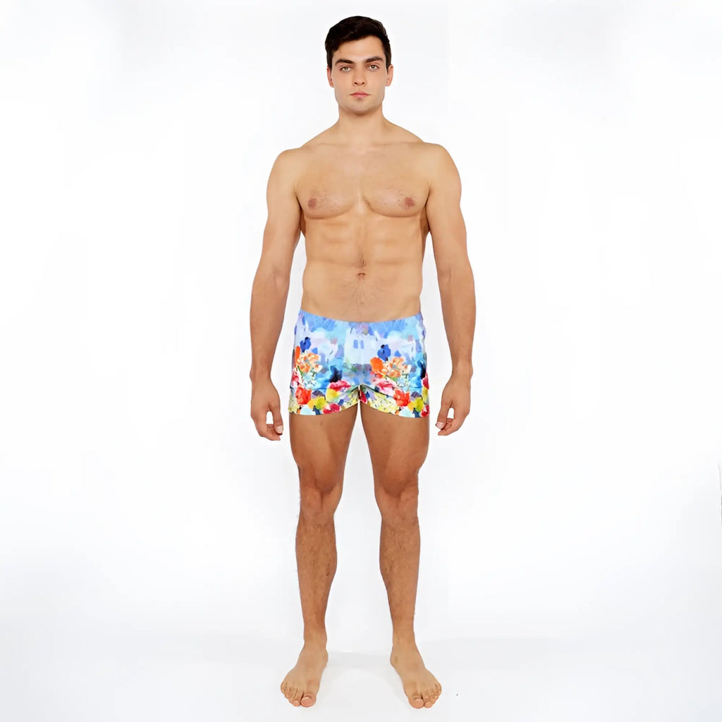 Men’s floral abstract printed swim shorts with vibrant red yellow and blue flowers on a light background