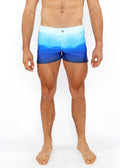 Blue gradient printed swim shorts with light to dark blue ombre pattern and white waistband for swimming