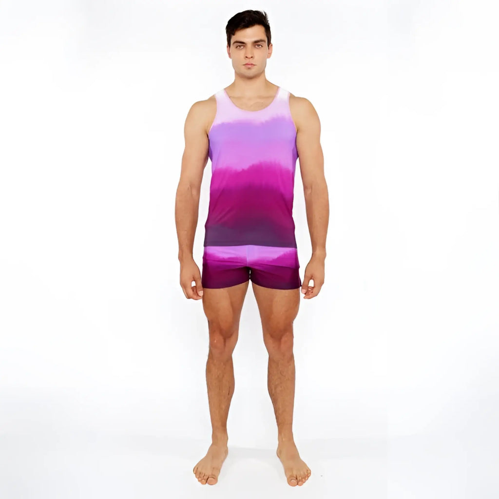 A man wearing a gradient printed swim short and matching purple and pink tie-dye tank top for casual summer wear