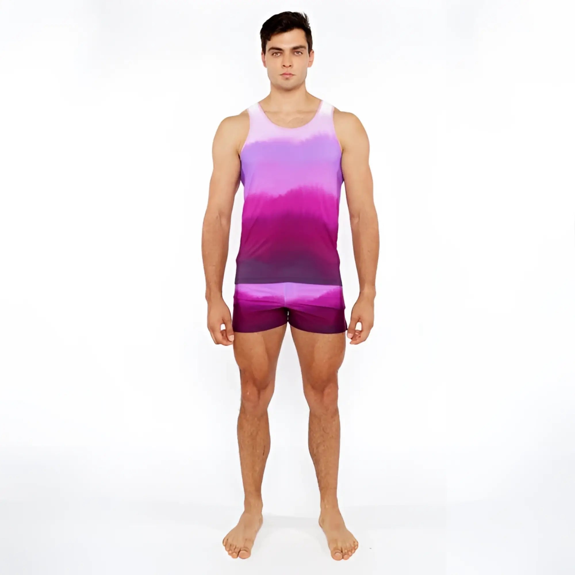 A man wearing a gradient printed swim short and matching purple and pink tie-dye tank top for casual summer wear