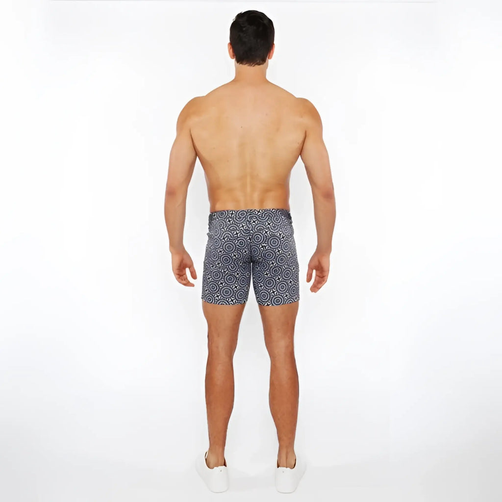 Men’s printed stretch knit short swim trunks in navy blue with white geometric pattern made from stretch fabric