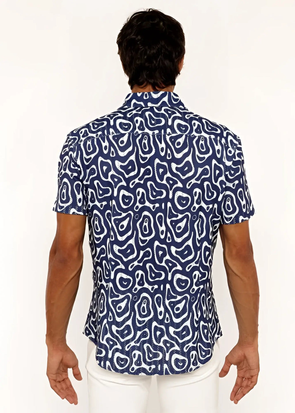 A navy blue short-sleeved open knit shirt with a bold white squiggly print pattern and button-up front