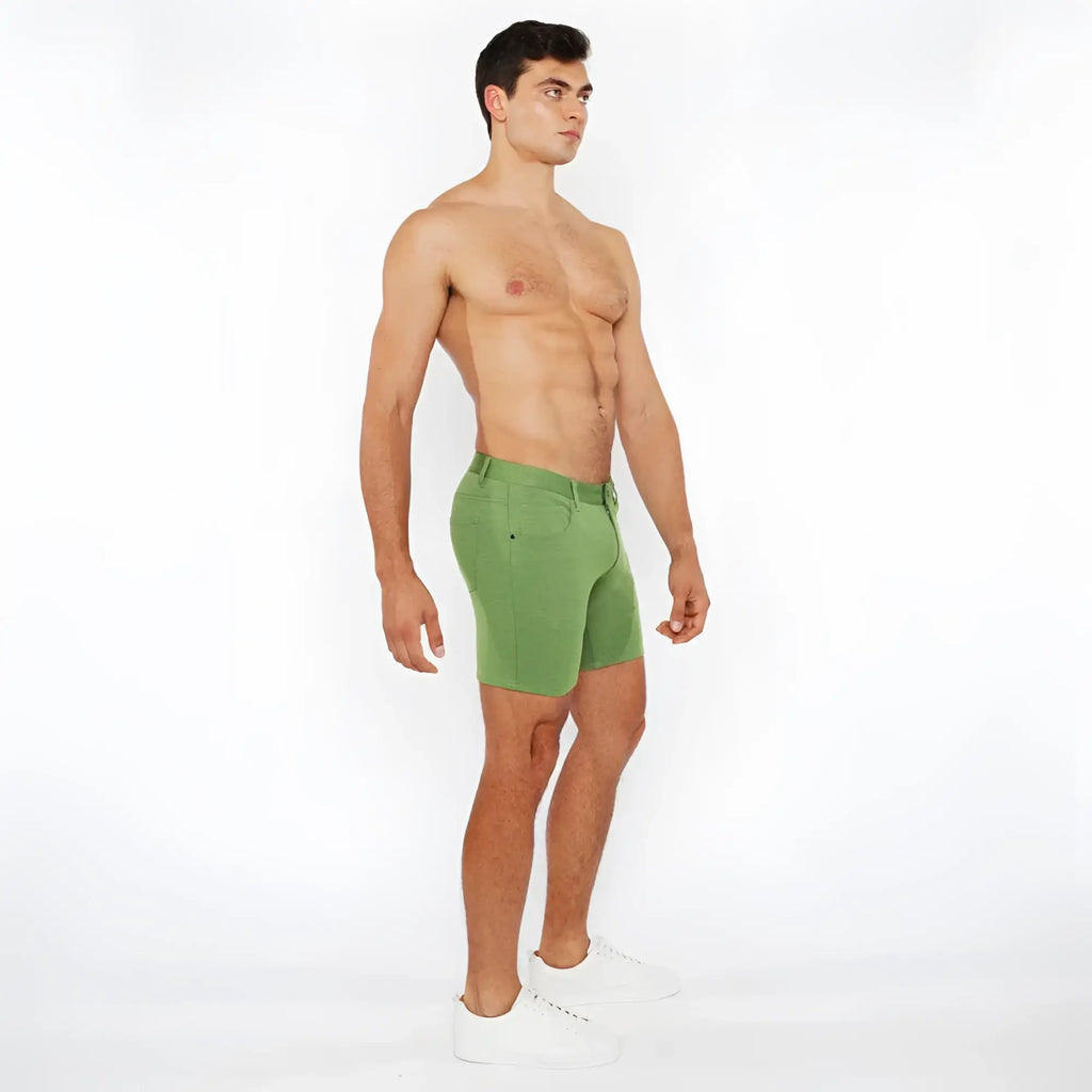 Green stretch knit short with fitted cut and visible stitching made of breathable athletic fabric