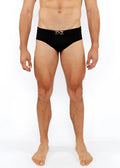 Black textured swim brief with a silver metallic front buckle featuring an interlocking double-x design