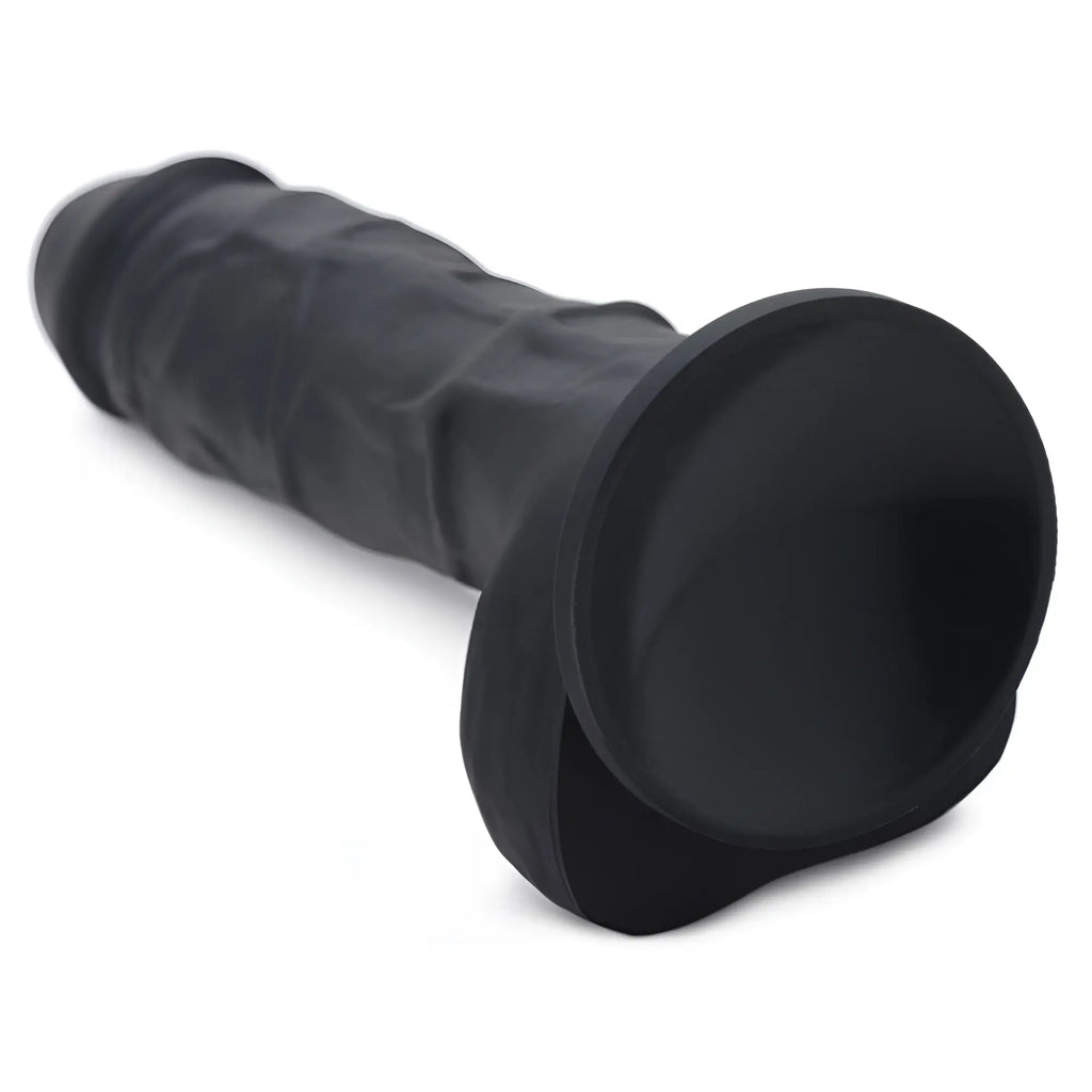 Strap U Power Pecker 7-inch black silicone dildo with a realistic texture and base for strap-on use against white.