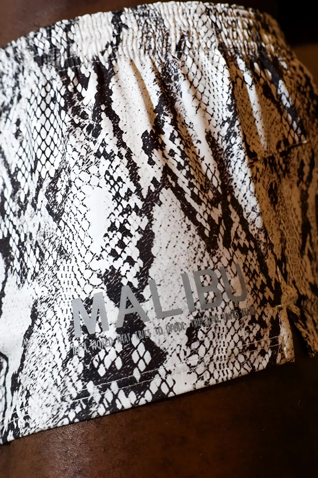 Black and white snake print stretch-it 2 athletic short shorts with gray malibu logo on waistband