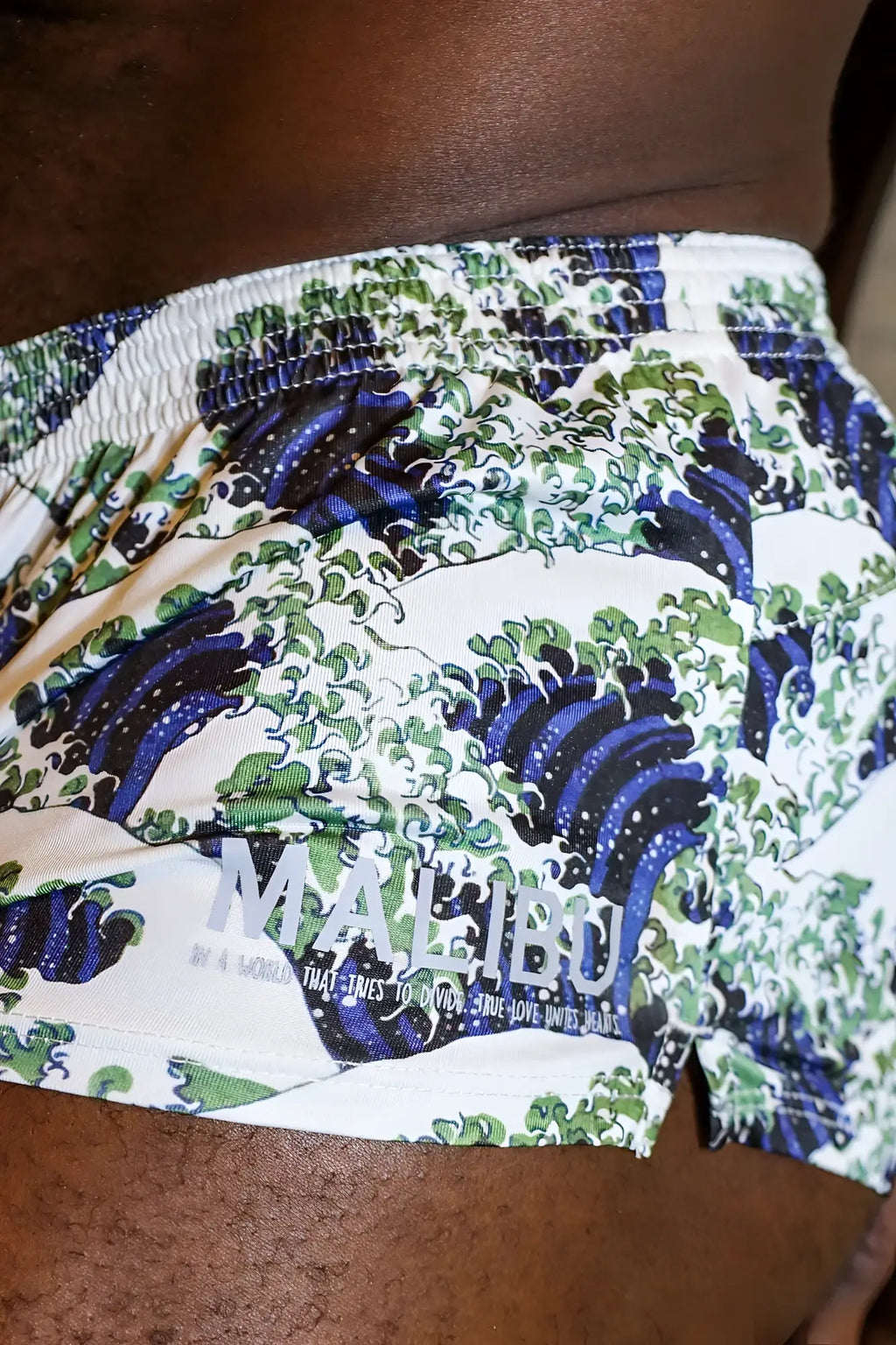 White stretch-it 2 inch athletic short shorts featuring blue and green wave pattern with gray malibu logo