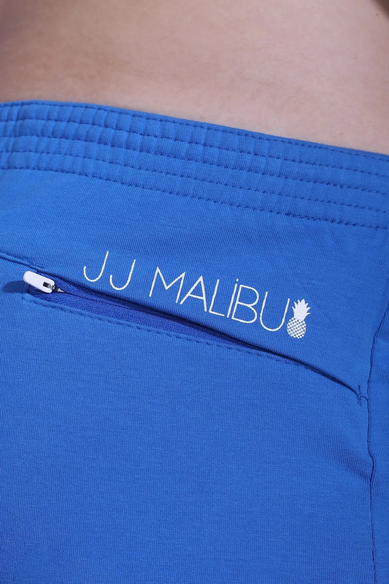 Bright blue jj malibu stretch-it 2 inch short shorts with white embroidered pineapple logo and stretch fabric