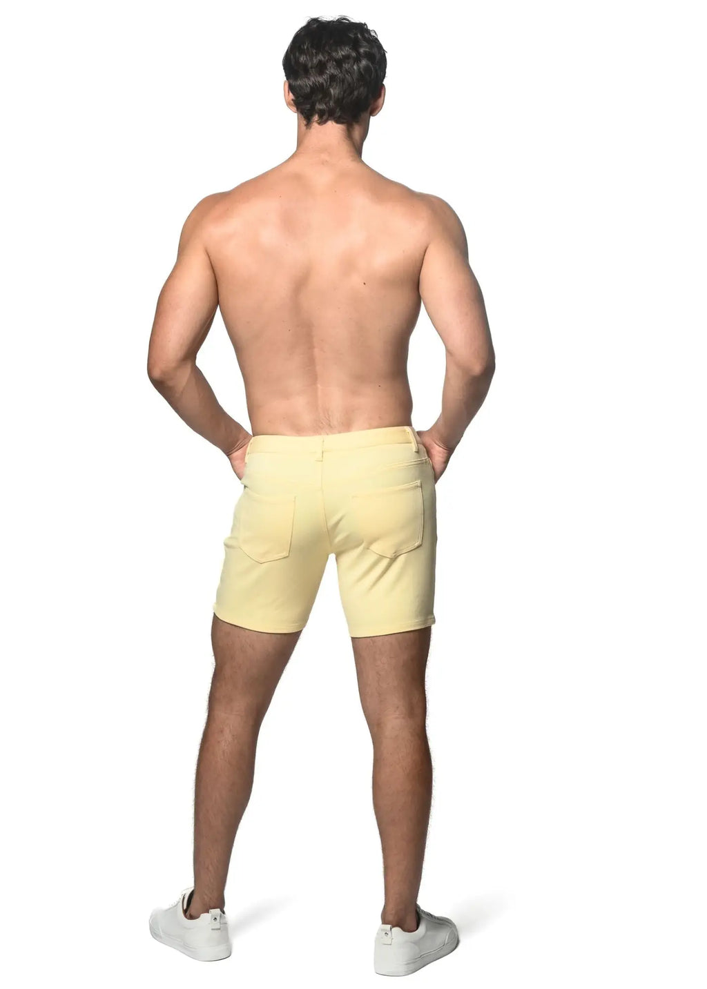 Back view of light yellow stretch knit shorts with a clean tailored fit and two back pockets