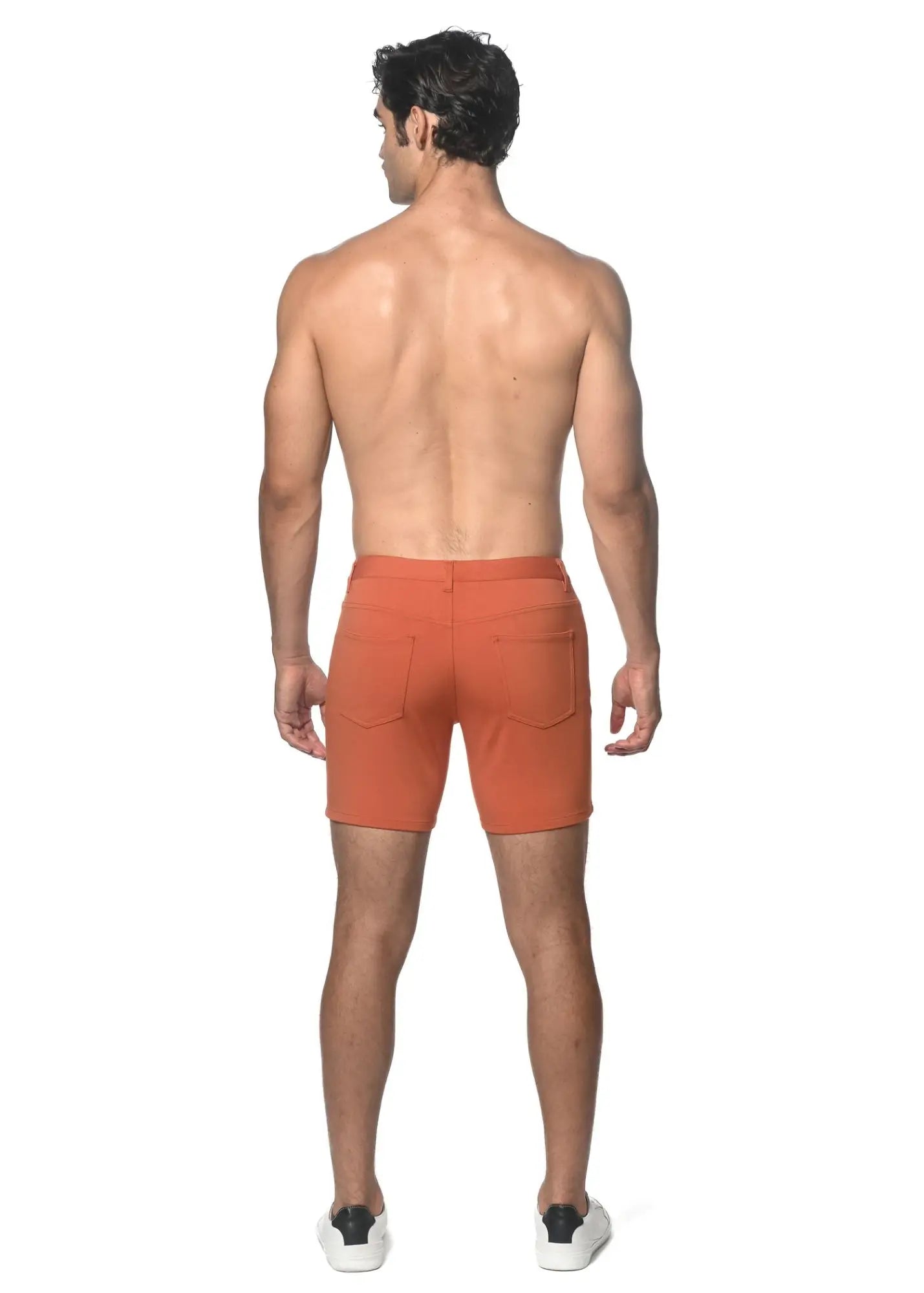 Back view of orange stretch knit shorts with two back pockets and a clean tailored fit