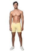 A pair of pale yellow stretch knit shorts with button closure and belt loops in a form-fitting design
