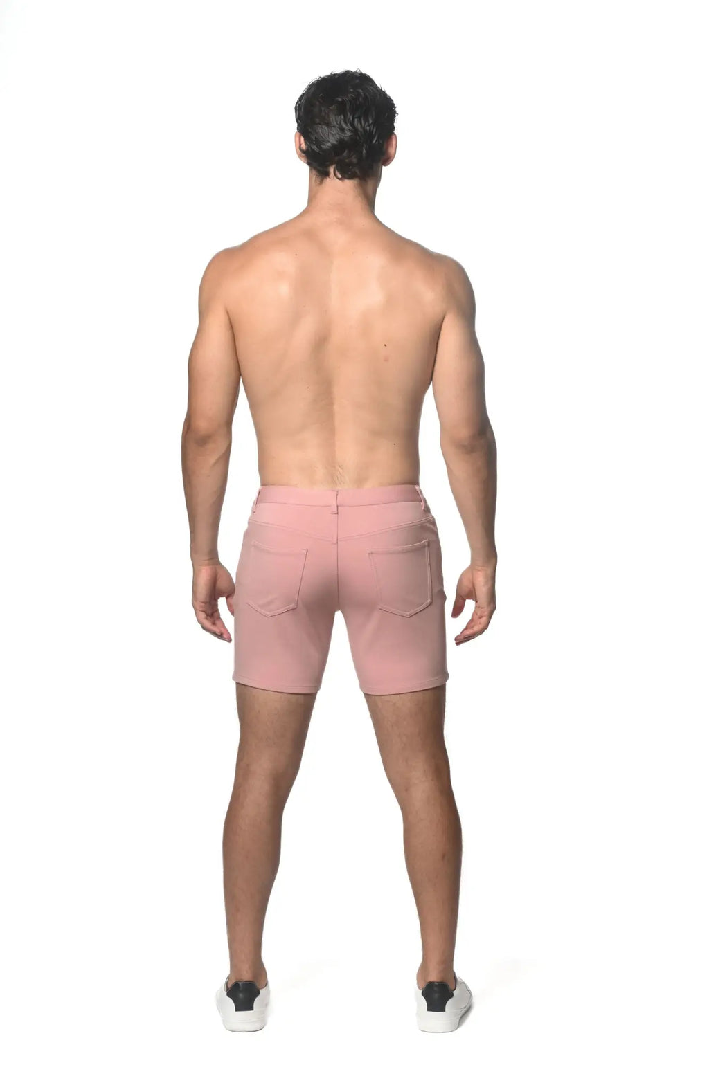 Pink stretch knit shorts with zipper closure and two back pockets shown from the back side