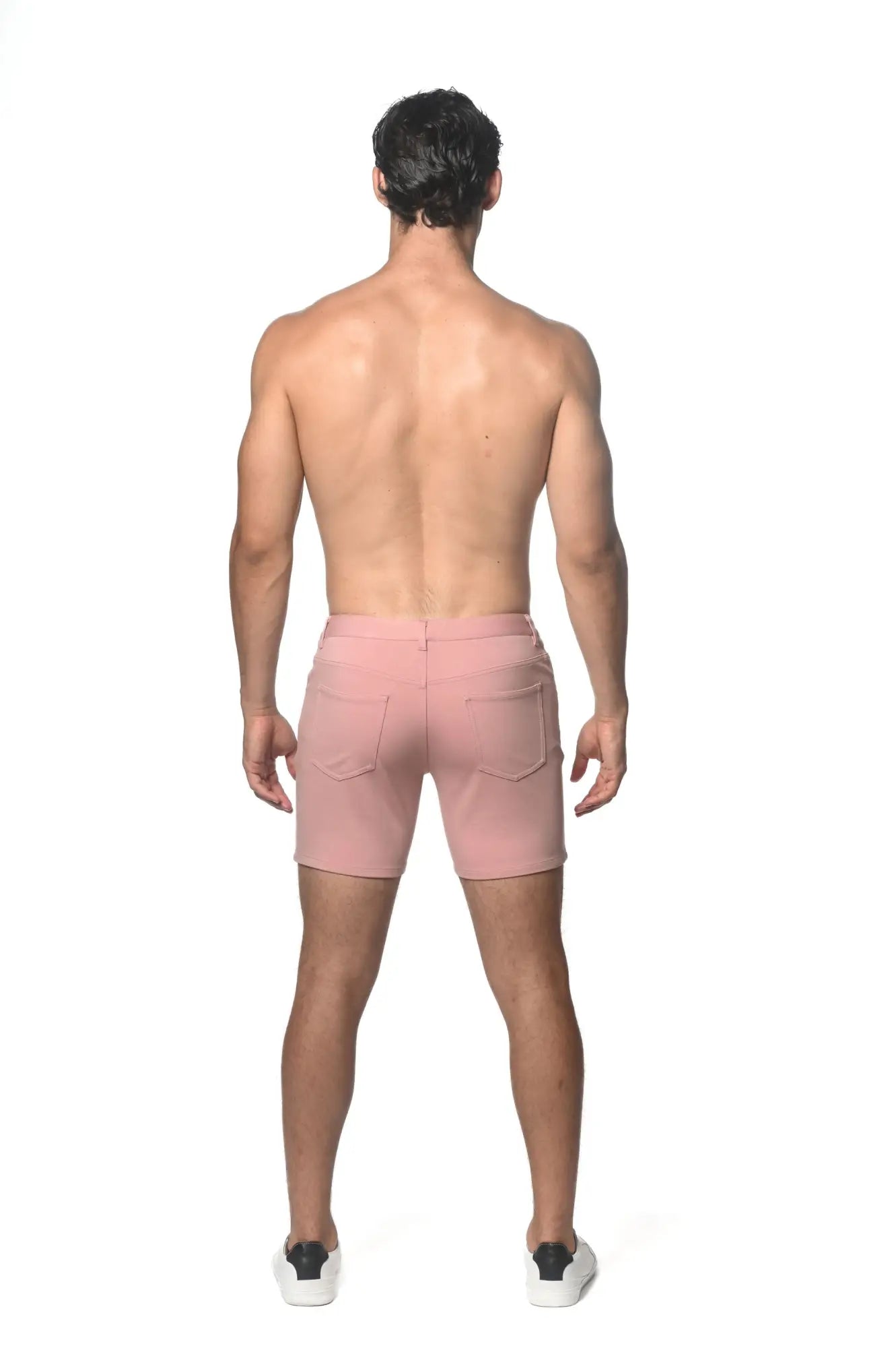 Pink stretch knit shorts with zipper closure and two back pockets shown from the back side