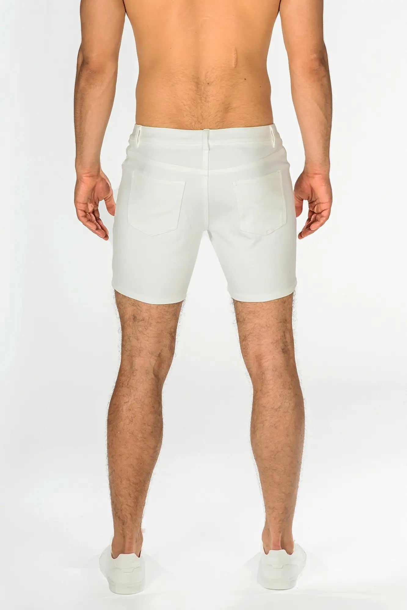 White stretch knit shorts with a tailored fit and classic back pockets shown from the back side