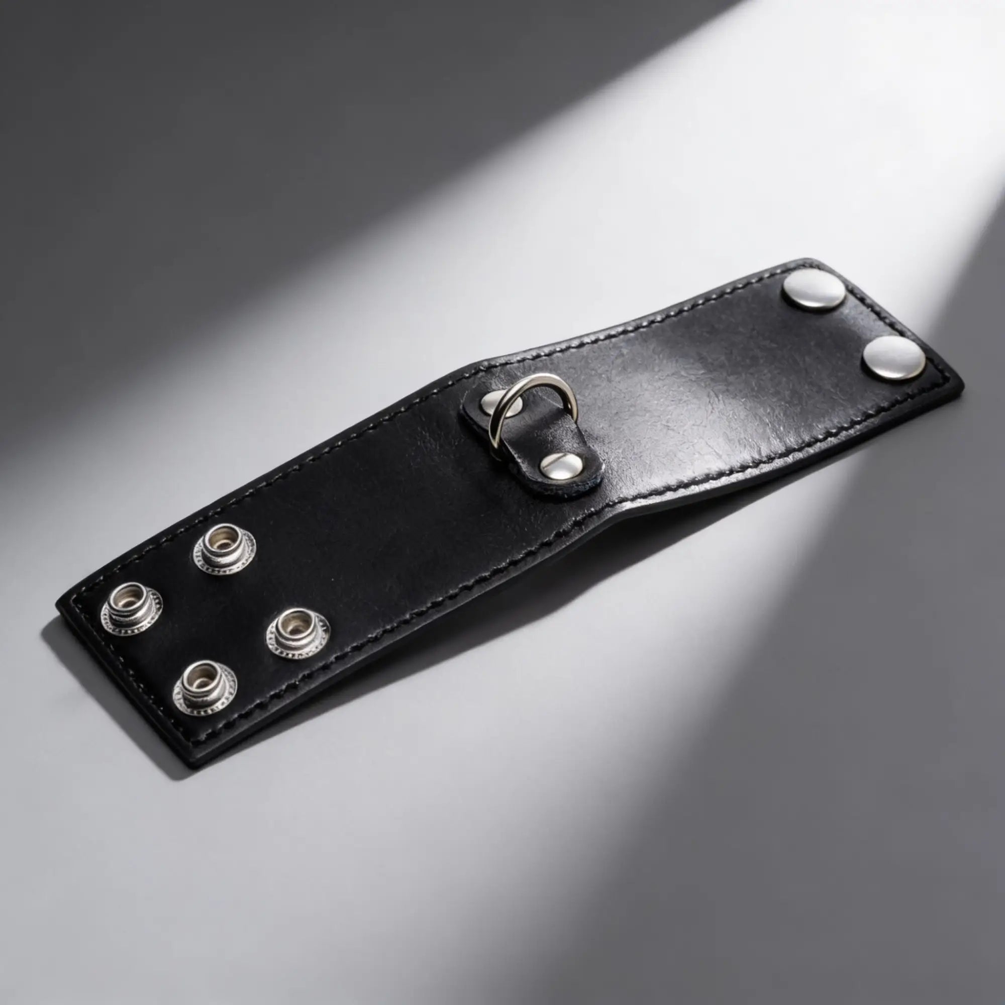 Strict 2 Inch black leather ball stretcher featuring a silver D-ring and secure metal snap button closures.