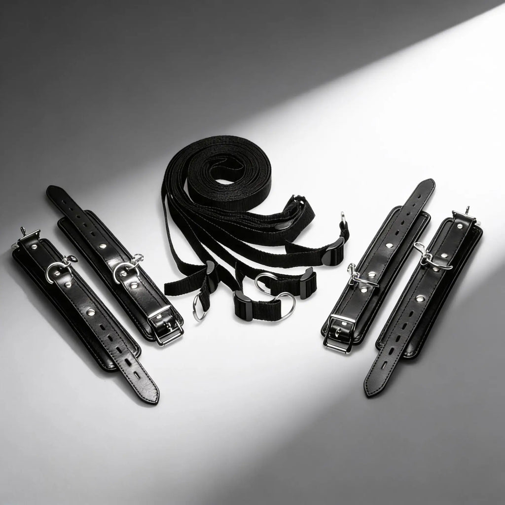 Strict Deluxe Bed Restraint System: Black leather-style cuffs and adjustable nylon straps with silver metal hardware.