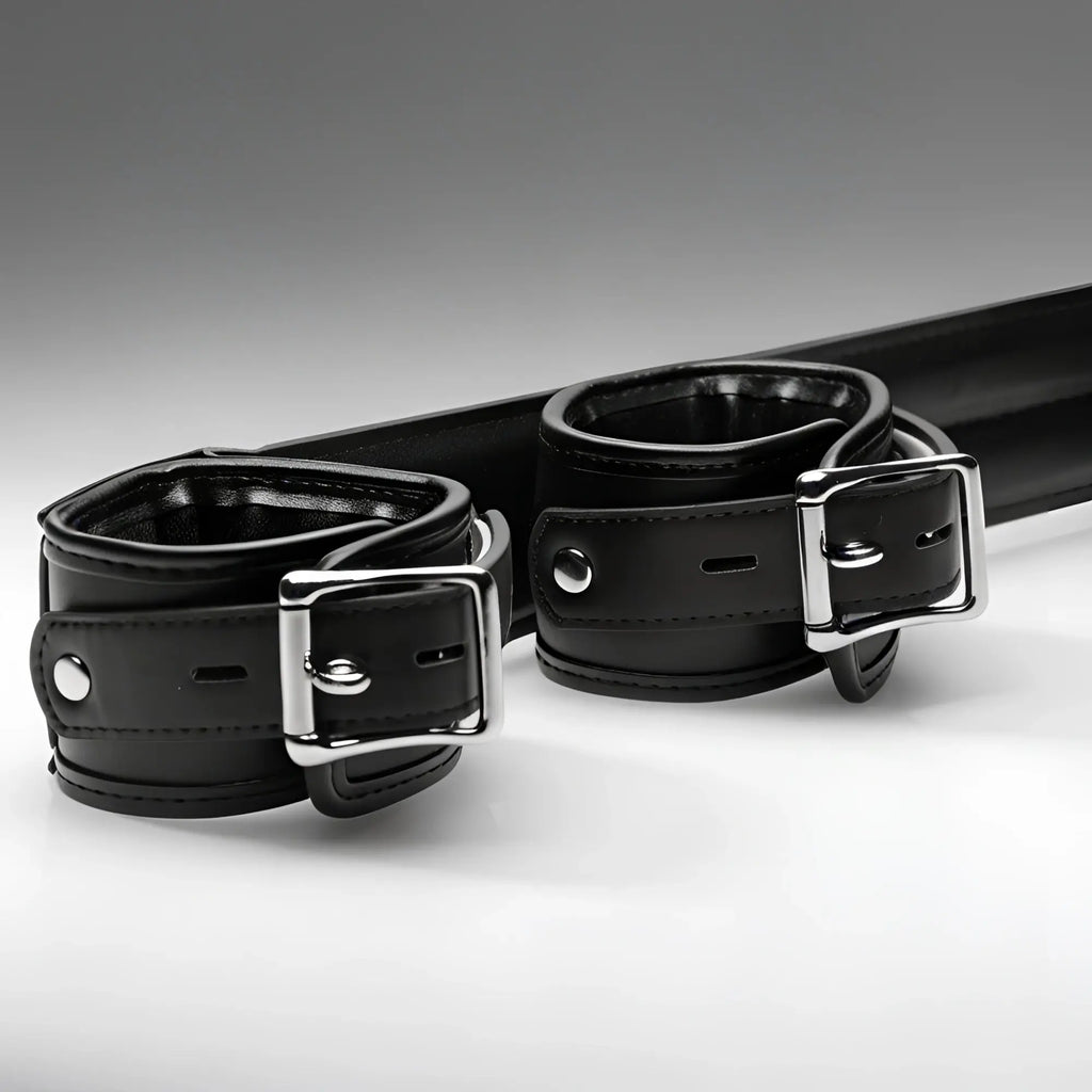 Strict Deluxe Spreader Bar: Black leather cuffs with silver metal buckles on a padded horizontal bar.