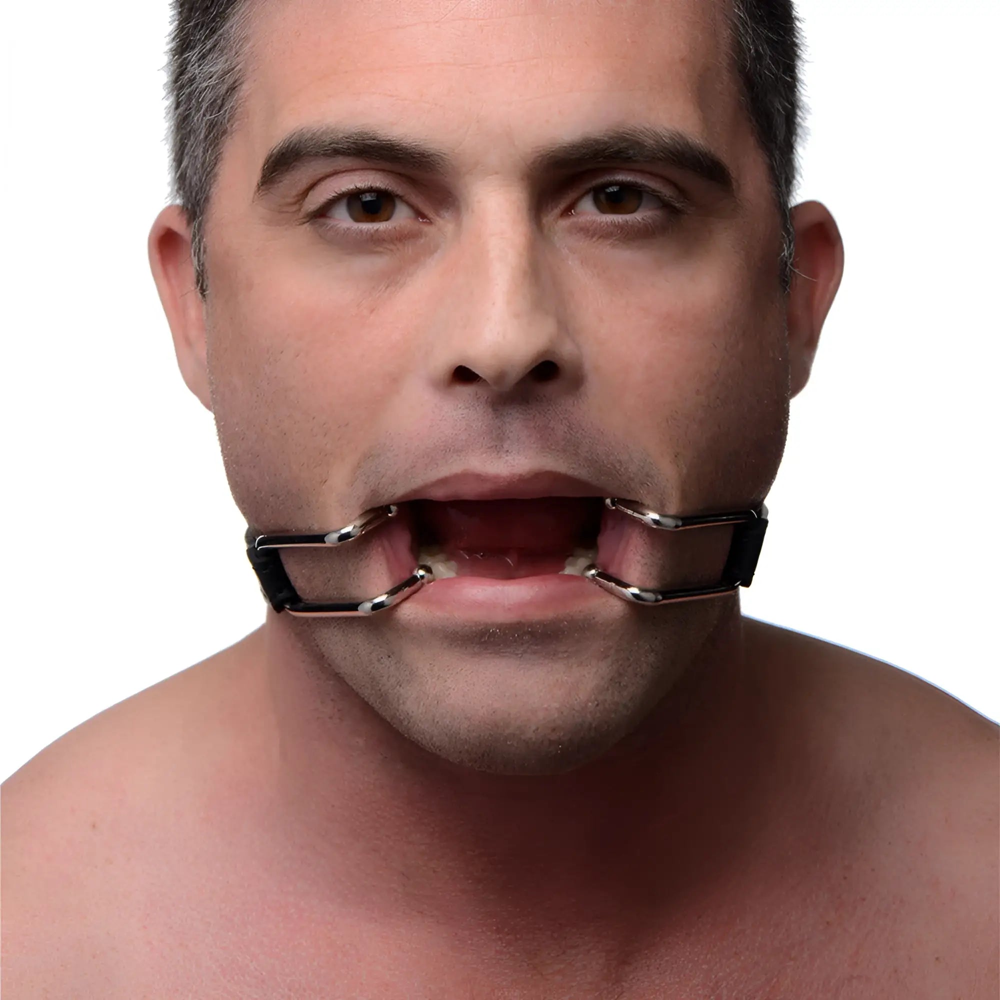Strict Hook Claw Mouth Spreader: A man wears a chrome-colored, metal-framed jaw opening device against his mouth.