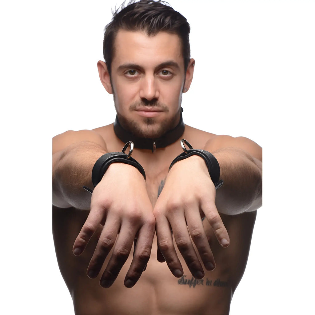 Strict Leather black premium leather collar and cuffs worn by a shirtless man with a white background.