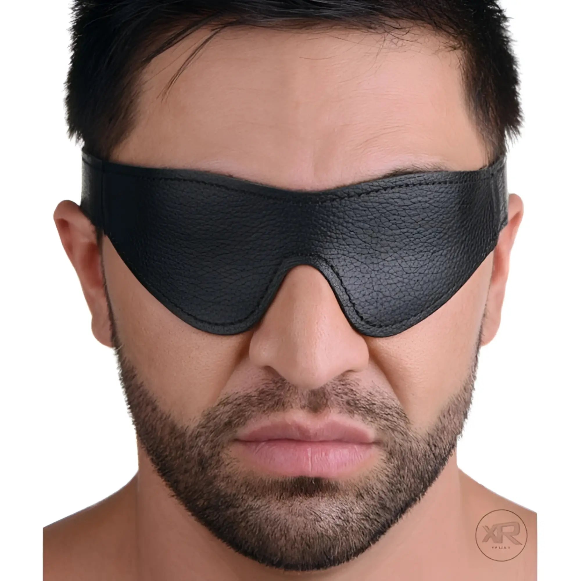 A man wearing a black, textured Strict Leather blindfold that covers his eyes.