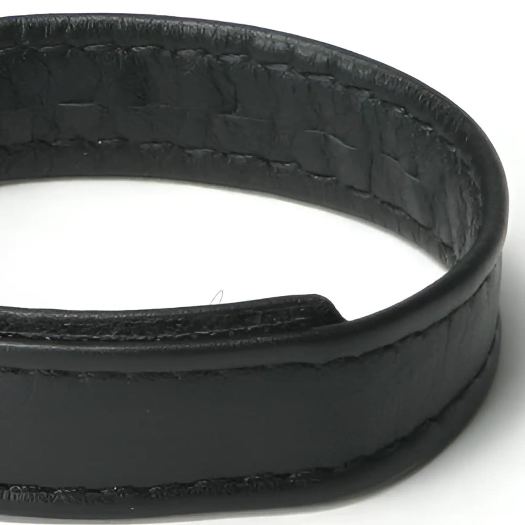 Close-up of a black leather cock ring with visible stitching and a textured inner surface.