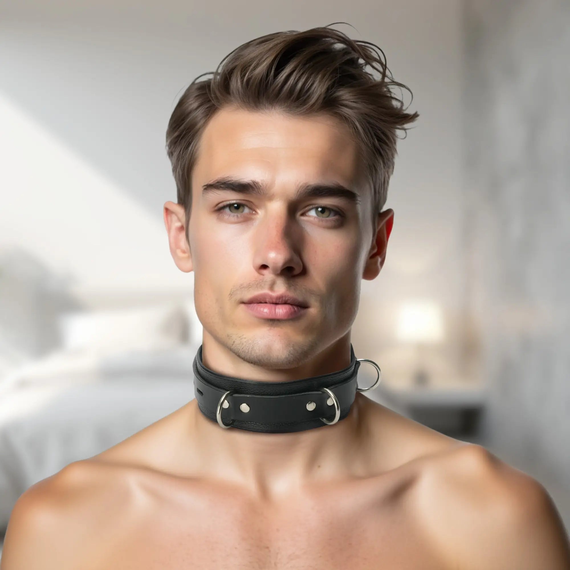 Strict Leather Deluxe Locking Collar: A black leather collar with metal O-rings worn by a man against a blurred room.