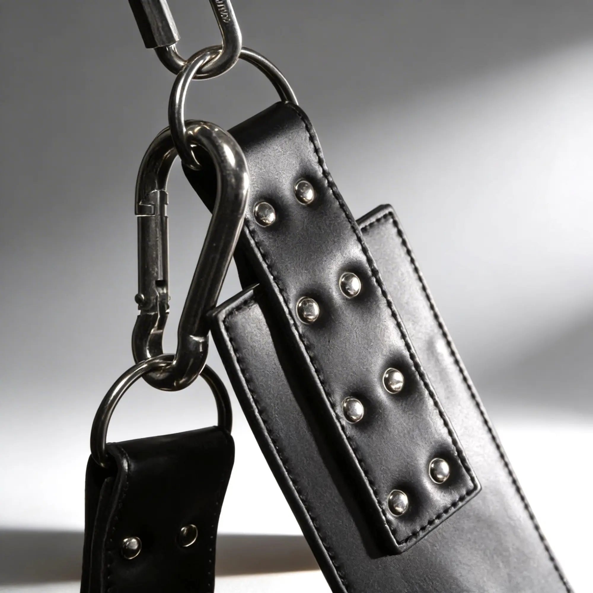 Strict Leather Lined Sling with black leather straps, silver metal rivets, and polished steel carabiner hardware.
