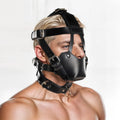 Strict Leather muzzle in black leather with adjustable straps, buckles, and a matching collar on a person.