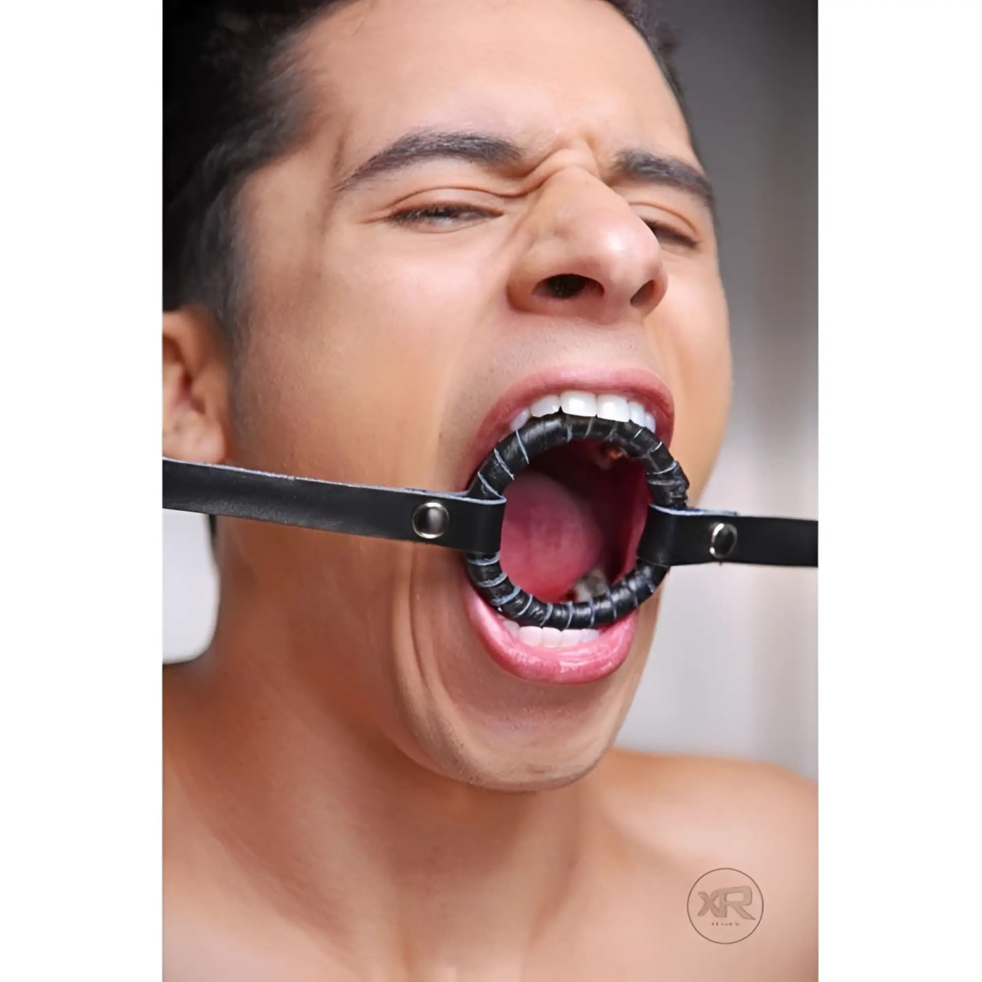 Strict Leather O-Ring Gag featuring a black, leather-wrapped ring and matching adjustable head strap on a person.