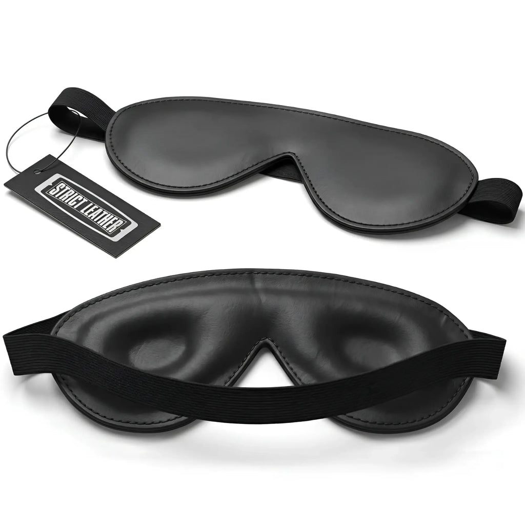Strict Leather Padded Blindfold: Two black leather, contoured sleep masks with elastic headbands and a branded tag.
