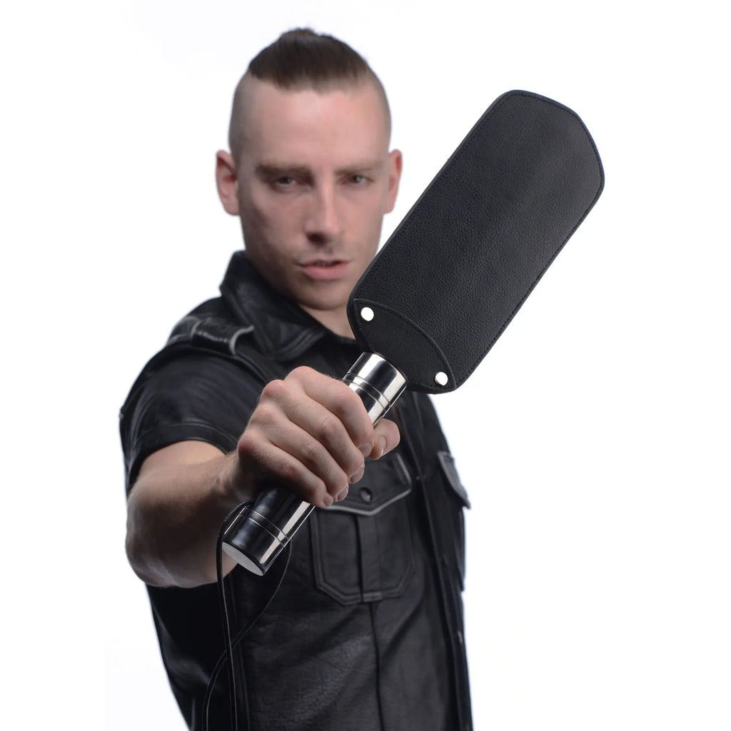 Strict Leather Padded Paddle: A man holds a black textured leather paddle with a silver metal handle.