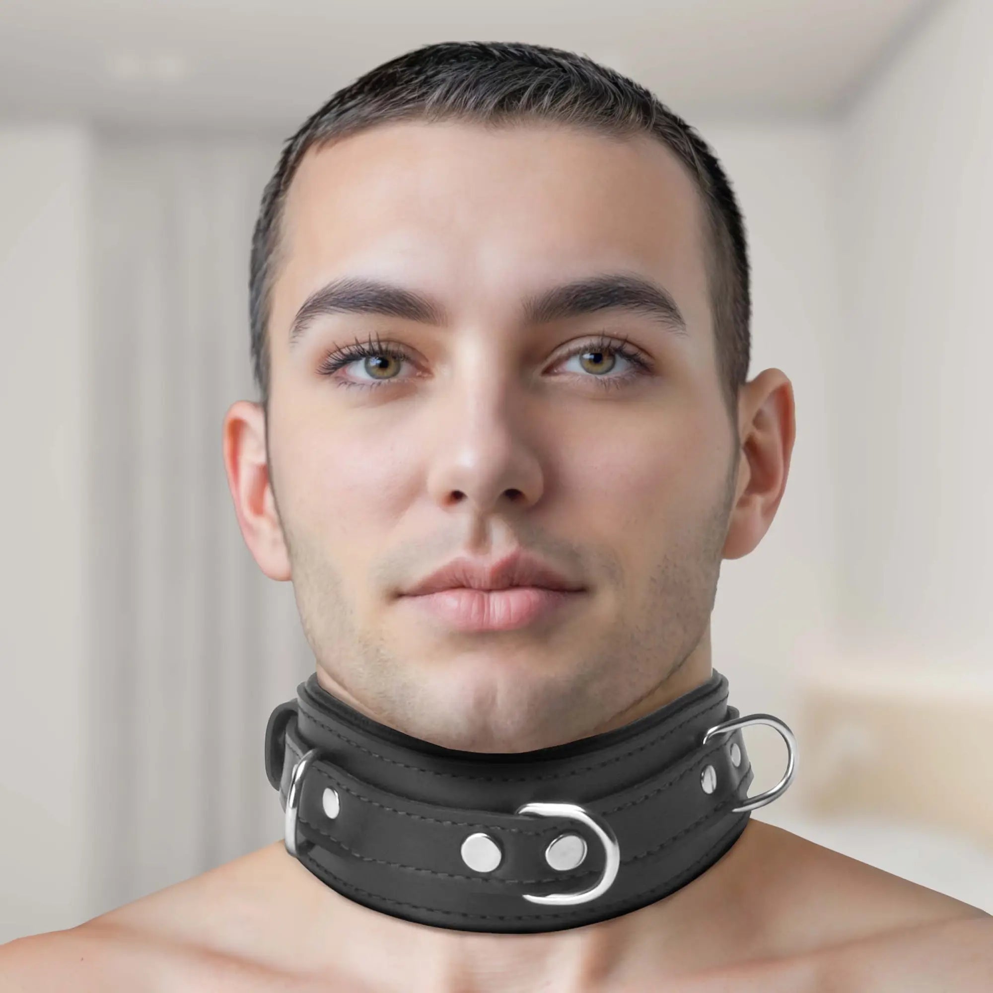 Strict Leather Premium Locking Collar: A man wearing a wide, black leather collar with silver hardware and metal rings.