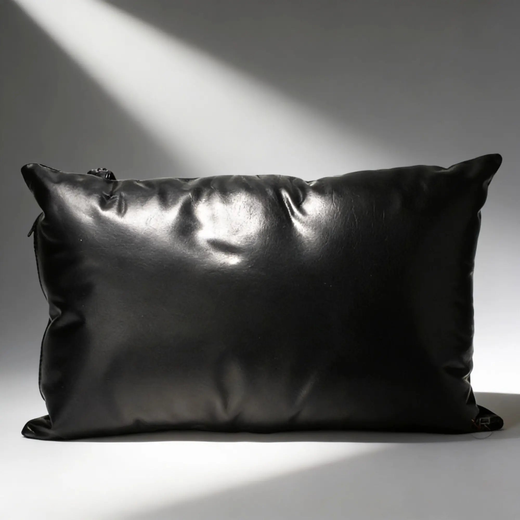 Strict Leather Sling pillow: a smooth, rectangular black leather pillow set against a grey background.