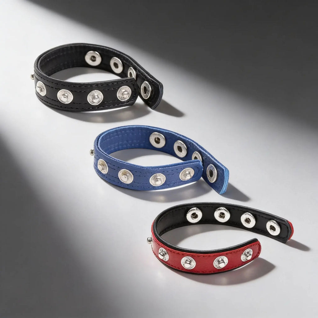 Three Strict Leather leather speed snap cock rings in black, blue, and red.