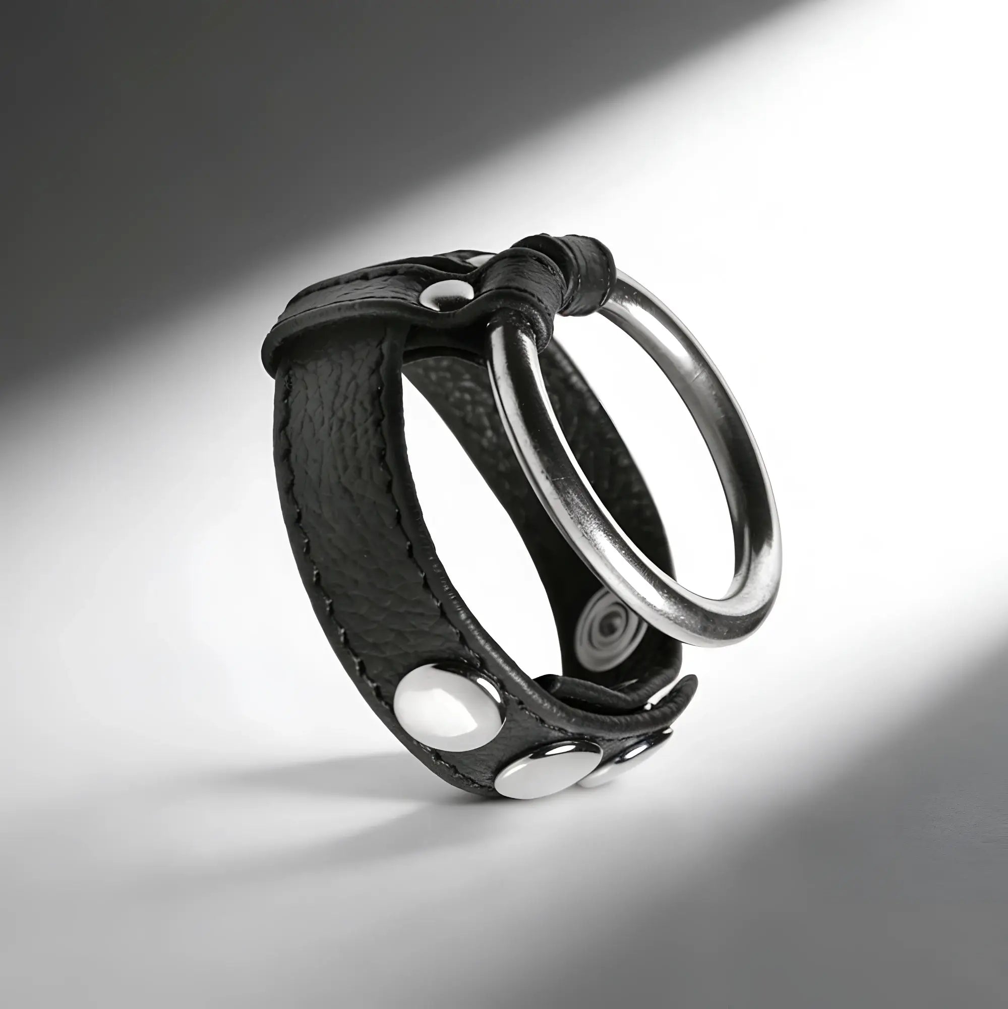 Strict Leather cock and ball ring made of black textured leather with silver metal studs and a large steel ring.