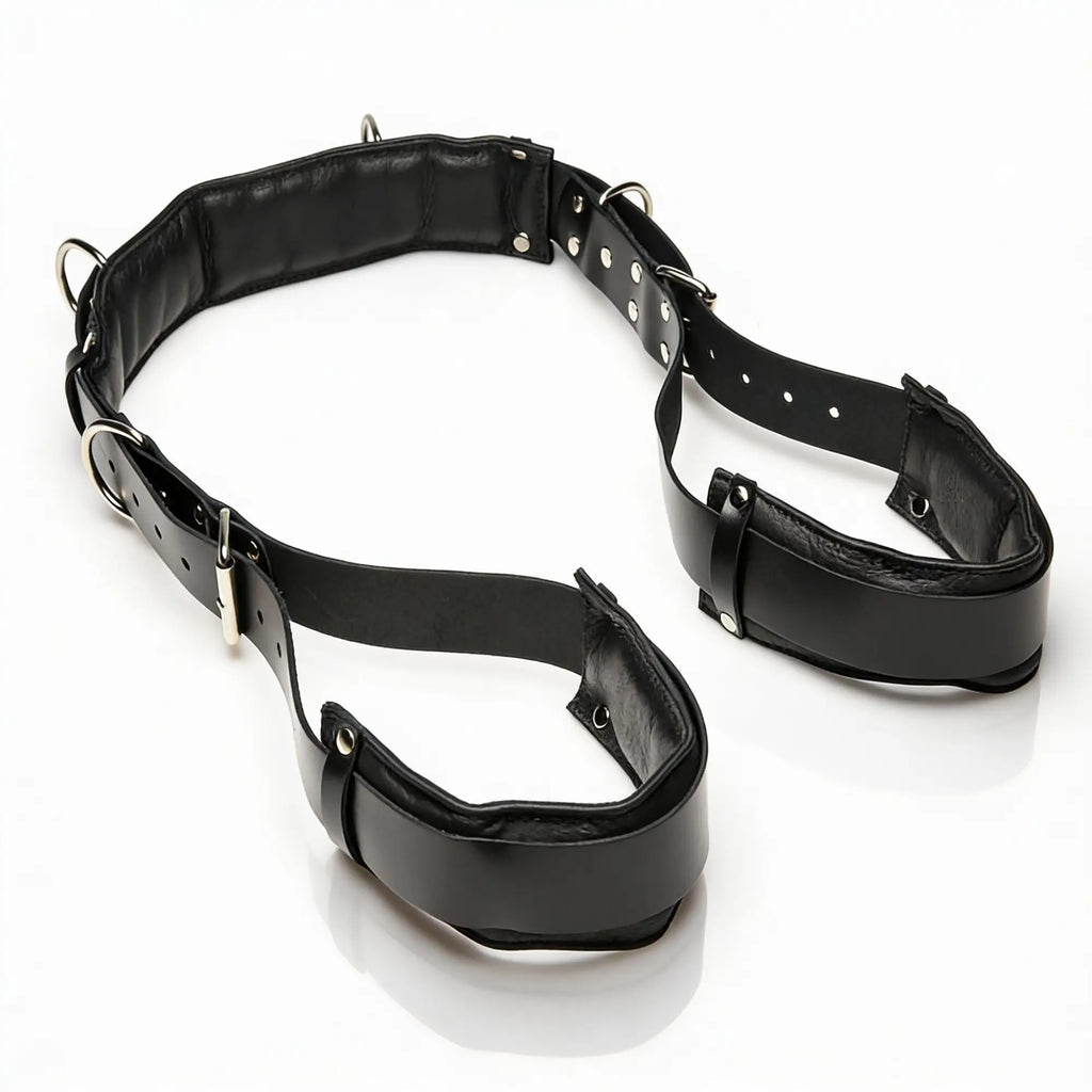 Strict Leather black leather thigh sling featuring padded cuffs, adjustable buckle straps, and silver-tone metal D-rings.