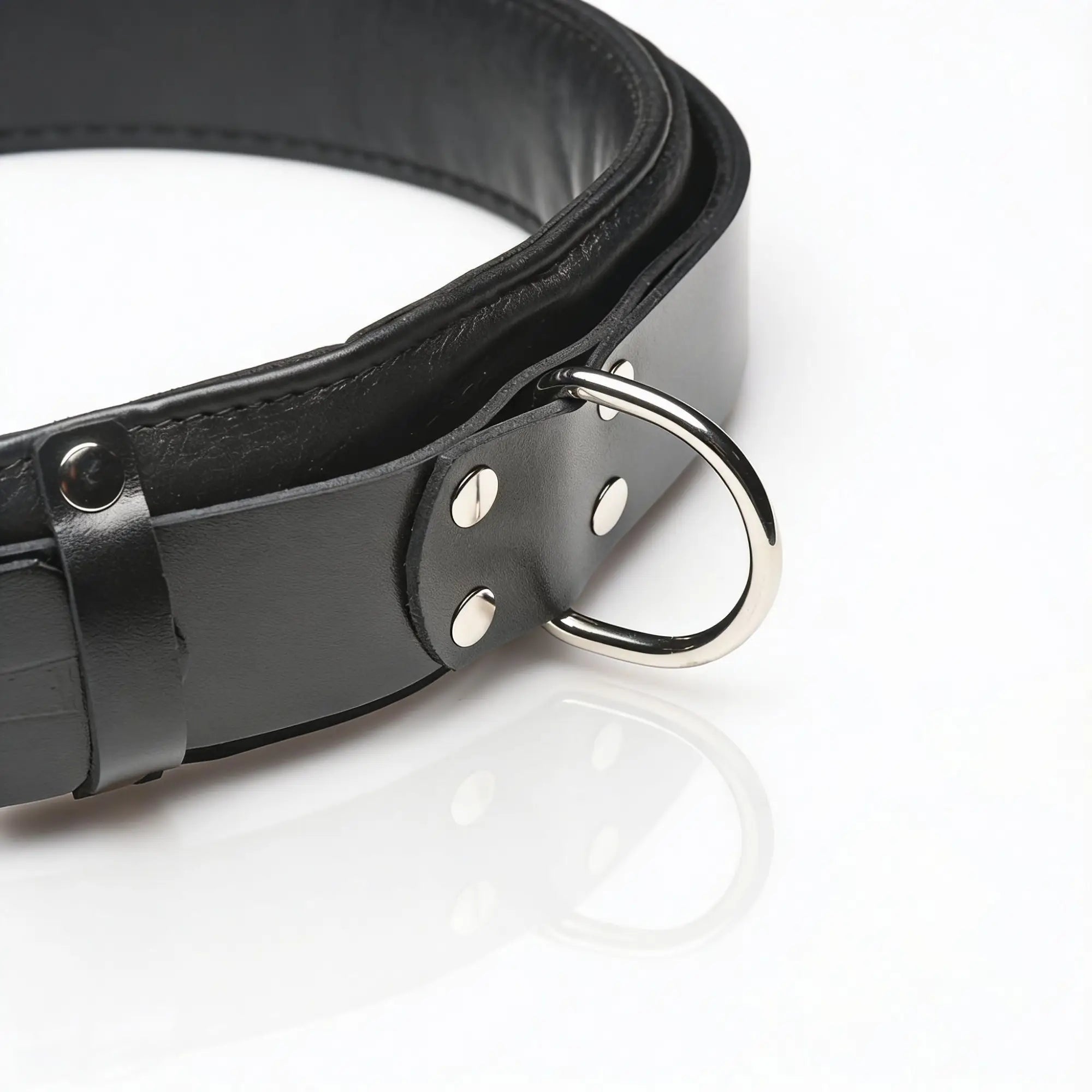 Strict Leather black leather thigh sling with silver-tone metal D-ring and rivets on a white background.