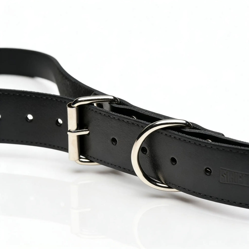 Strict Leather Thigh Sling: Black leather strap with a silver metal buckle and O-ring on a white background.