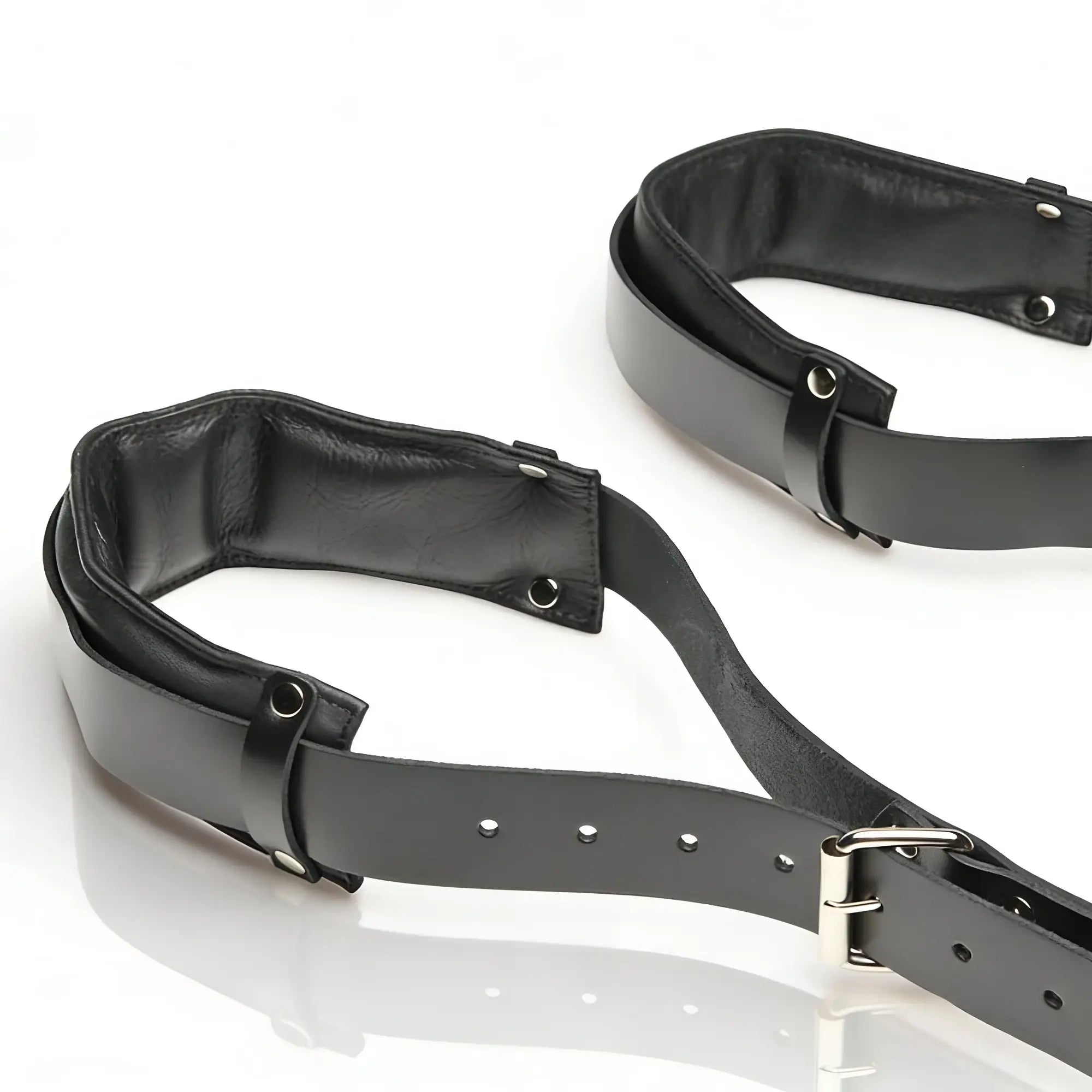 Strict Leather Thigh Sling: Pair of adjustable black leather leg restraints with padded interior and metal buckles.