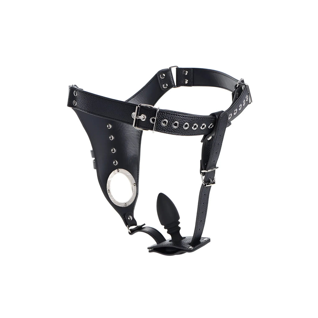 Black leather strict male chastity harness with silver hardware and an attached black silicone anal plug.