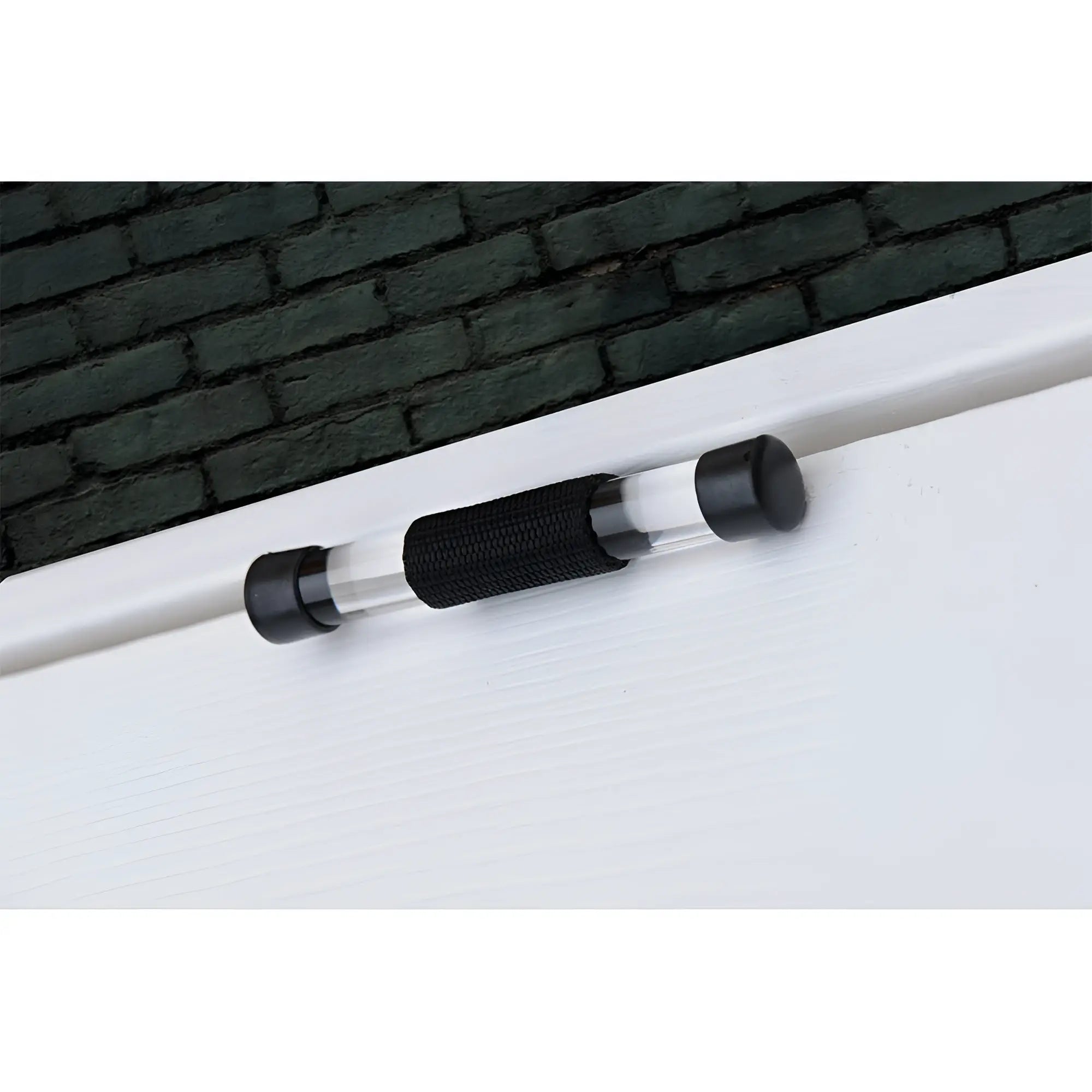 Strict Over the Door Restraint: A clear, cylindrical rod with black end caps and a textured black center grip on a door.