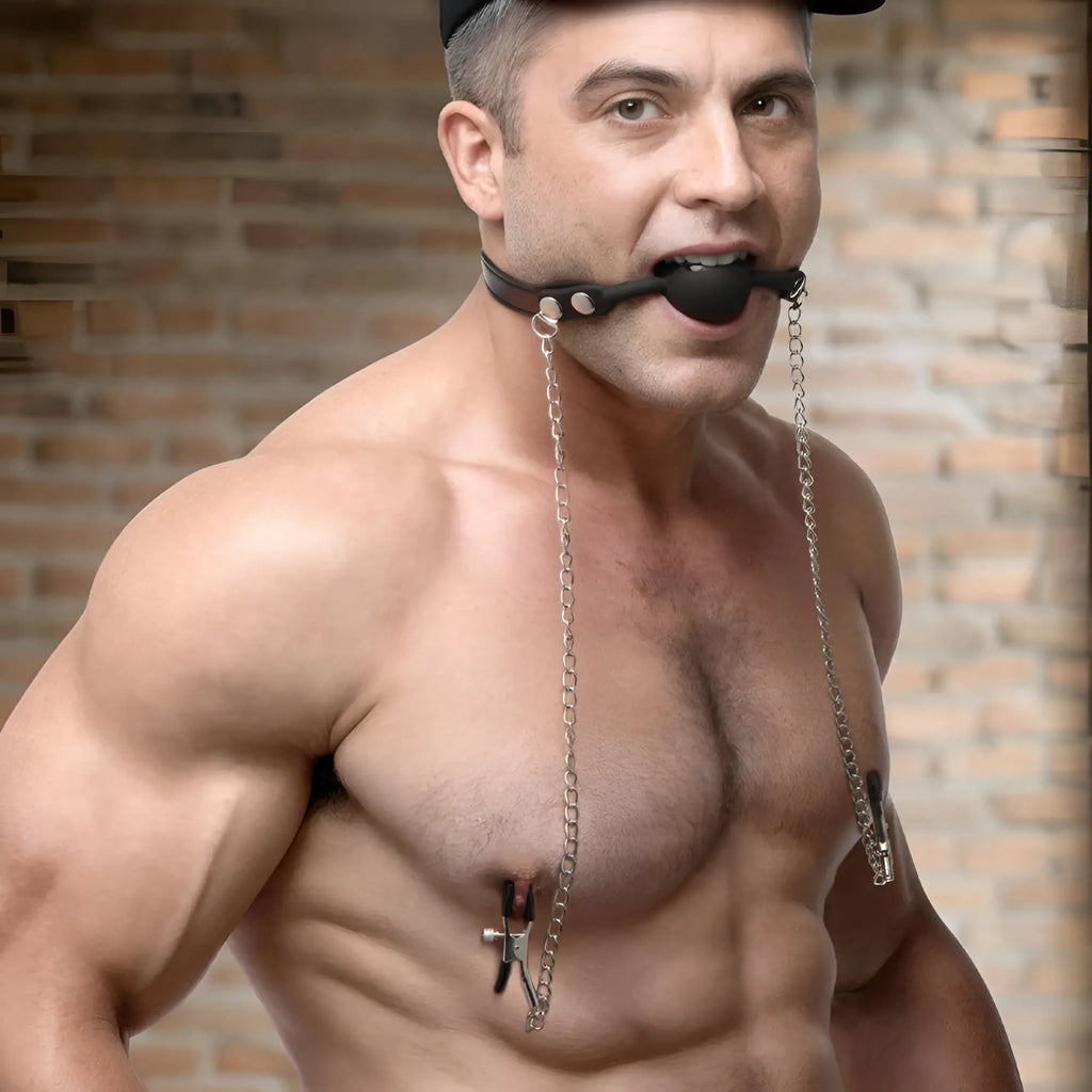 Strict Silicone Ball Gag with Nipple Clamps featuring a black silicone ball, leather strap, and silver metal chains.