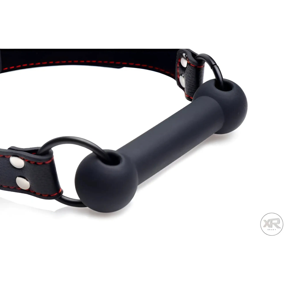 Strict Silicone Bit Gag: A black silicone bar bit with a matching black leather strap featuring red stitching.