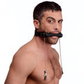 Man wearing a black Strict Silicone Bit Gag with silver chains connecting to black nipple clamps on a white background.